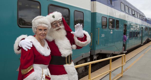 Mr and Mrs Claus wait for passengers to board the Coaster Holiday Express train