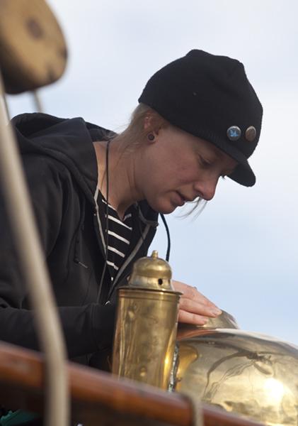 Lynette Davis of Wisconsin polishes the brass compass aboard the Hawaiian Chieftain. 