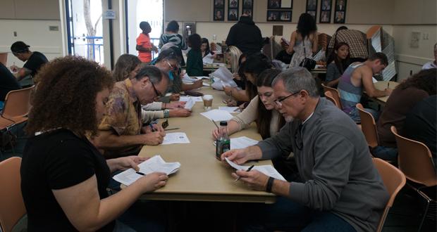 People filling out paperwork during open casting