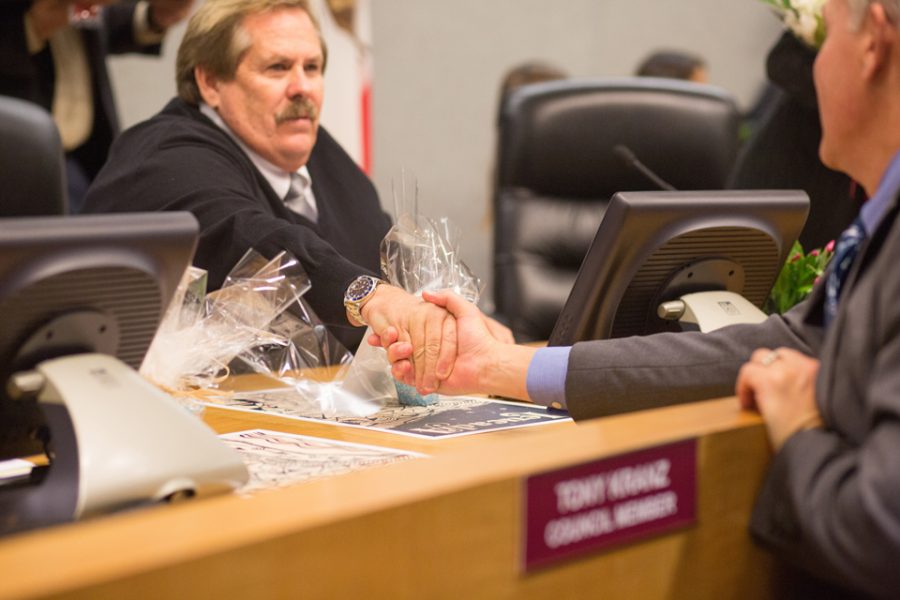 Encinitas Councilman Mark Muir shakes former county Supervisor Dave Roberts’ hand on Dec 13 during the start of the new council's first meeting. (Photo by Cam Buker)