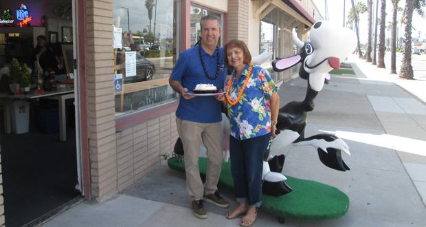 Todd Stephenson owner of Estate Warehouse in Oceanside will lead a dessert auction at the Brother Benno's "Ohana Luau." Linda Donahue,auxiliary co-chair, presents him with a pie. (courtesy photo)