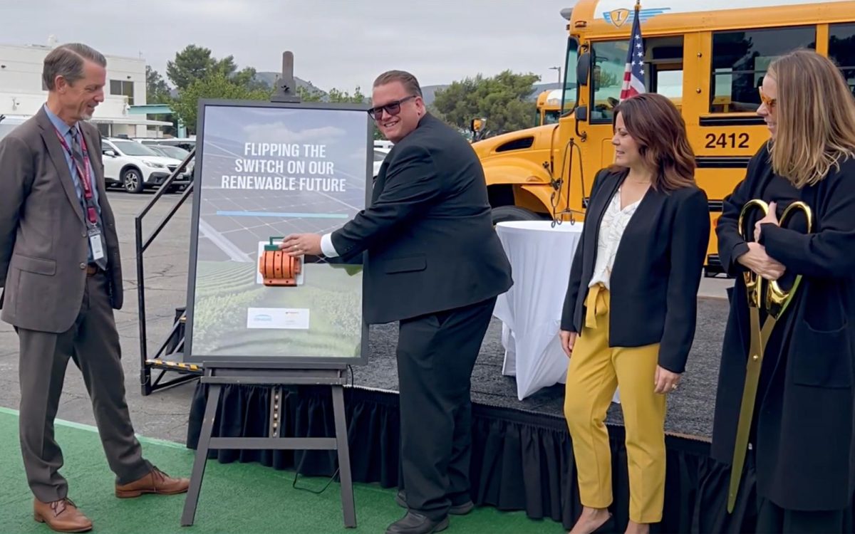 San Marcos Unified School District transportation Executive Director Mike Sawyer launches new clean-energy infrastructure during a “flip the switch” ceremony on Oct. 15. To Sawyer’s left is district Superintendent Andy Johnsen. Second from right is Assistant Superintendent of Business Services Erin Garcia. Nancy Rorabaugh, senior program development manager ENGIE North America, holds scissors for the project's ribbon cutting. (SMUSD photo)